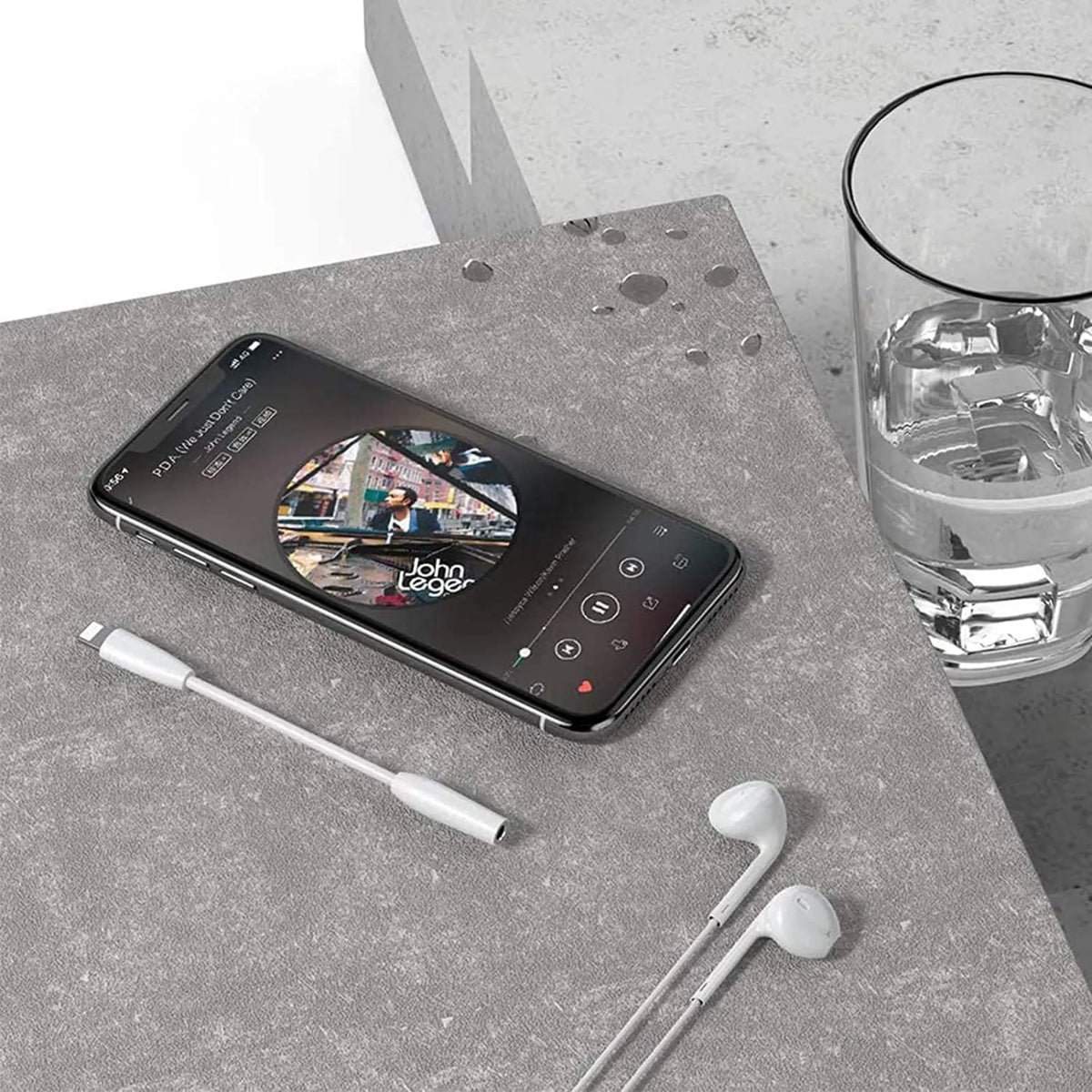 IPhone noir affichant musique avec écouteurs blancs et câble Lightning pour adaptateur jack 3,5 mm