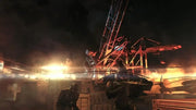 Soldat blindé sombre de Metal Gear Solid V: The Phantom Pain PS4 au milieu des décombres enflammés