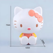 Figurine Hello Kitty Mimmy blanche avec nœud corail, tenue orange et jaune assise